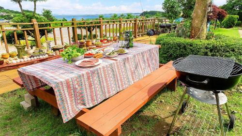a picnic table with a bbq and a grill at Taean loghouse pension in Taean