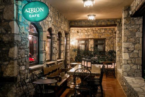 a restaurant with tables and chairs and a sign on the wall at Atrion Highland Hotel in Elatochori