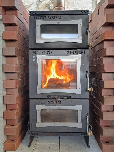 a pizza oven with a fire inside of it at Kyeongju Withbebe Dockchae Kids Poolvilla in Chŏngnae-dong