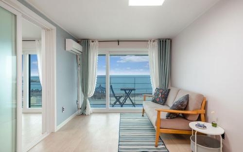 a living room with a couch and a view of the ocean at Yeongdeok Samsari Morning Pension in Yeongdeok