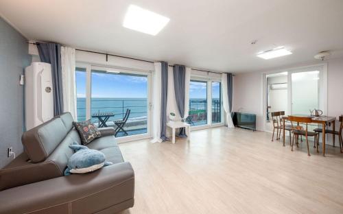 a living room with a couch and a view of the ocean at Yeongdeok Samsari Morning Pension in Yeongdeok