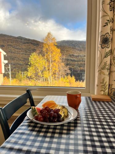 a plate of fruit on a table in front of a window at Vatnahalsen Høyfjellshotell in Myrdal