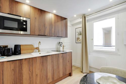 une cuisine avec un évier et un micro-ondes dans l'établissement Superb apartment with AC - 1BR-2P - Arts et Métier, à Paris