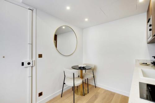 Cette chambre comprend une table, des chaises et un miroir. dans l'établissement Superb apartment with AC - 1BR-2P - Arts et Métier, à Paris