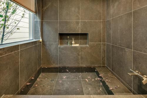 a bathroom with a tiled shower with a window at Jincheon Walking the Memory 3 Pension in Jincheon