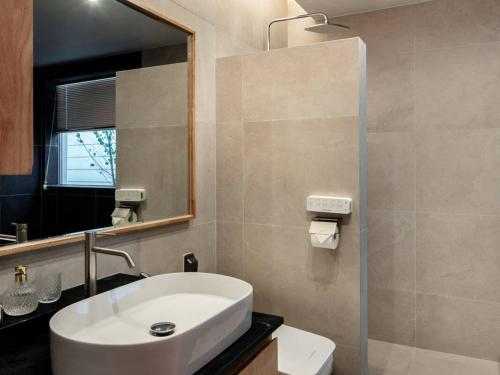 a bathroom with a white sink and a mirror at Jincheon Walking the Memory 3 Pension in Jincheon