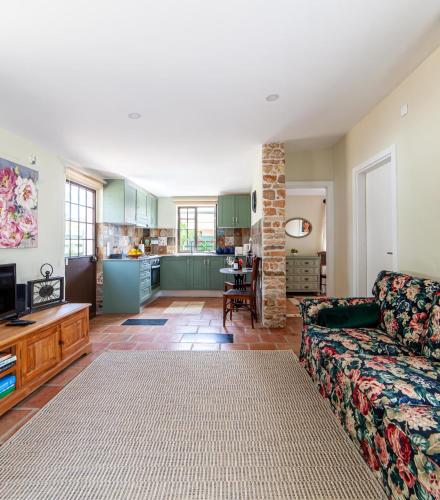 a living room with a couch and a kitchen at Quinta Aida Cottage and B&B Suites in Lagoa