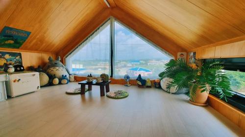 a living room with a large window and a table at Jaeju Stay Oneul in Jeju