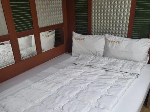 a bed with white sheets and pillows in a room at Sillim Flower in Seoul