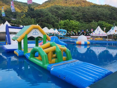 a water park with a water slide in the water at Goesan Joryeong Pension in Sangch'o