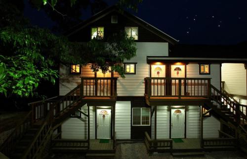 a house with a porch and a deck at night at Cheongju Okhwadaestory Pension in Cheongju
