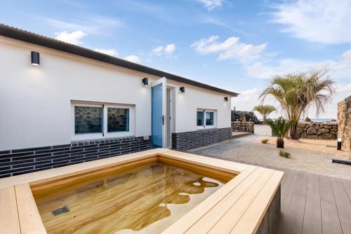 a house with a koi pond in front of it at Jeju Slow Stay in Jeju