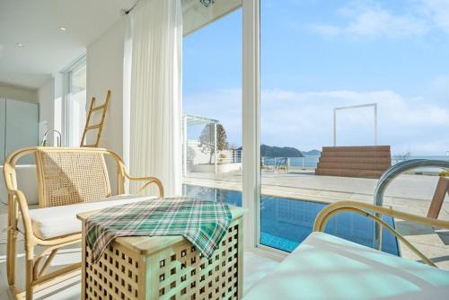 a living room with a view of a swimming pool at Namhae Yeogi Namhae in Namhae