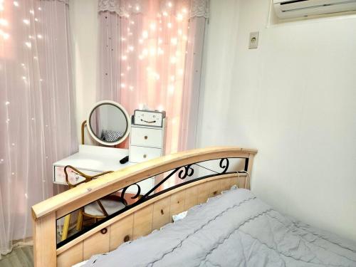 a bedroom with a bed and a mirror and a window at Anmyeondo Titicaca Pension in Taean