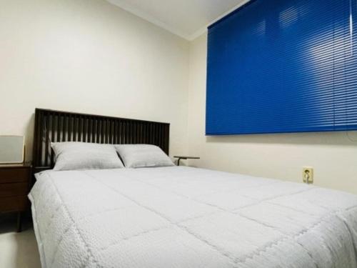 a bedroom with a large bed with a blue painting on the wall at Iksan Dalgwa 7 Pence Pension with dogs in Iksan