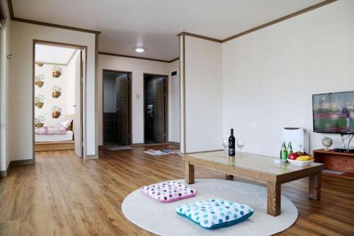 a living room with a table and two pillows at Sancheong Jirisan Noul Pension in Sancheong