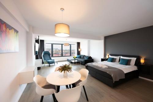 a hotel room with a bed and a table and chairs at Lounge 8 Studios in Oradea
