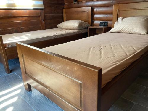a pair of beds in a room with wooden walls at Brvnara Leska in Jarmenovci
