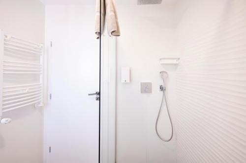 a white bathroom with a shower with a shower at Lounge 8 Studios in Oradea