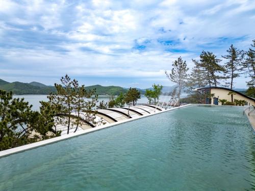 a swimming pool with a view of a body of water at Goheung Tuttiamo Pension in Goheung