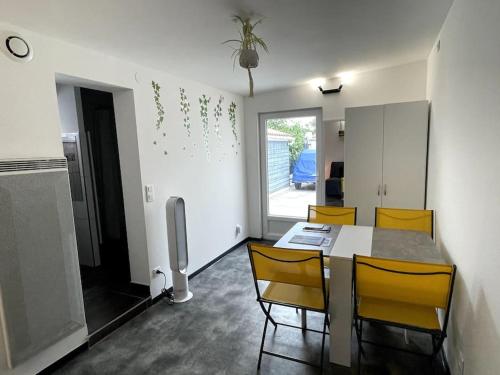 une salle à manger avec une table et des chaises jaunes dans l'établissement Studio de 25m carré refait à neuf, proche tram B et fac, à Pessac
