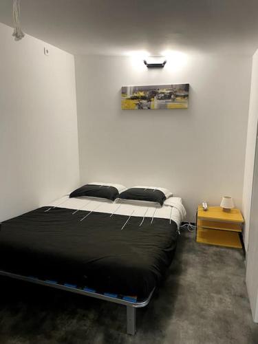une chambre avec un lit dans une pièce blanche dans l'établissement Studio de 25m carré refait à neuf, proche tram B et fac, à Pessac