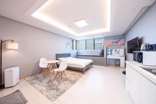 a kitchen and living room with a bed and a table at Jaeju Delma Pension in Jeju