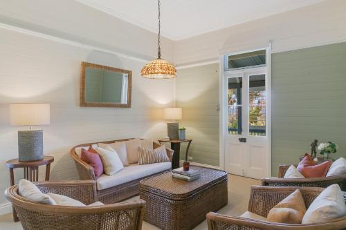 a living room with rattan furniture and a chandelier at Glenelg Residence in Murwillumbah