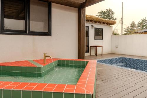 a house with a jacuzzi in the backyard at Jeju Stay Hyun in Jeju