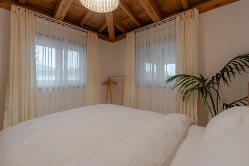 a bedroom with a white bed and a window at Jeju Stay Hyun in Jeju