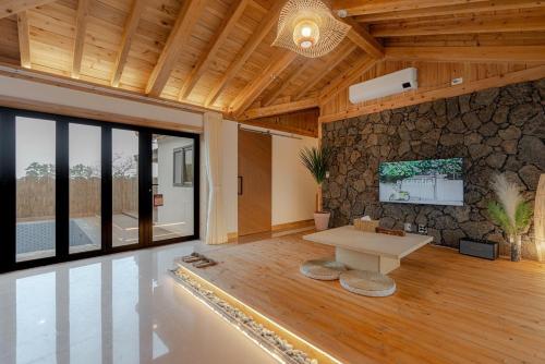 a living room with a table and a stone wall at Jeju Stay Hyun in Jeju