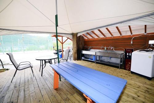 a kitchen with a blue bench in a tent at Poem Pension in Incheon