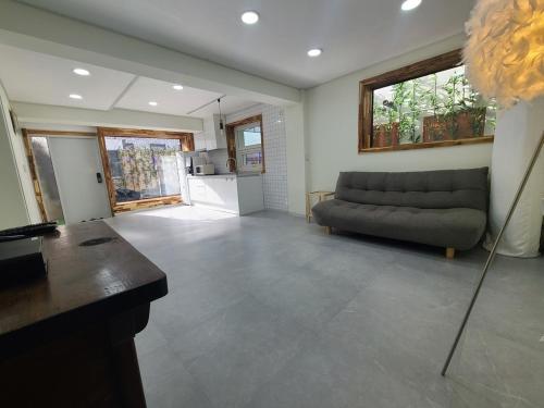 a living room with a couch and a kitchen at Jeonju Kkol Guest House in Jeonju