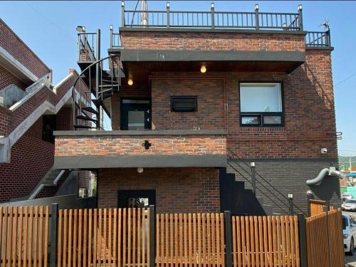 a brick building with a balcony on top of it at Suncheon Stay Rev in Suncheon