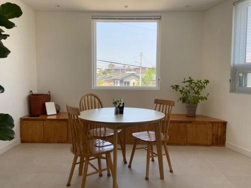 a table and chairs in a room with a window at Suncheon Stay Rev in Suncheon