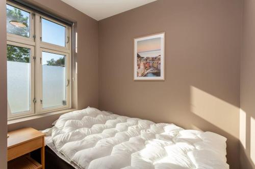 a large white bed in a room with windows at 2 bedroom appartment - walking distance to the Technology Park, City Center & Uni - Fully furnished in Kongsberg