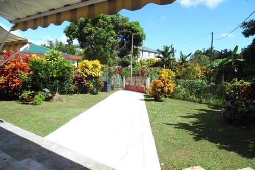 a walkway in a garden with flowers and plants at Holiday Home Villa Kay Malouz in Saint-Joseph