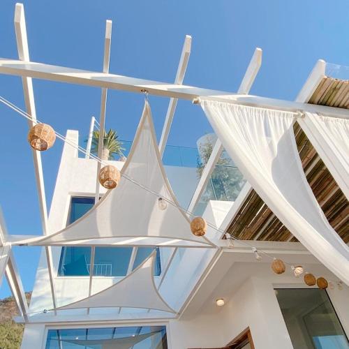 a white house with white curtains hanging from it at On the Sunset Mansion in Geoje 