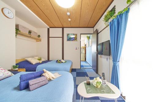 a hotel room with two beds and a couch at Belmont 203 3min to Station Easy Access Ueno Asakusa Skytree Sleeps 4 in Tokyo