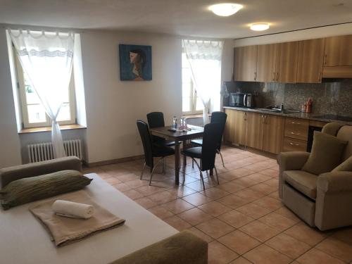 a living room with a table and chairs and a kitchen at Vacanza a Miglieglia in Miglieglia