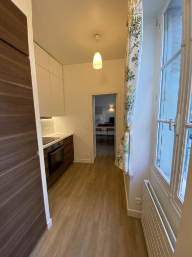 une cuisine avec des placards blancs et une grande fenêtre dans l'établissement Château de Versailles 800m à pied, à Versailles