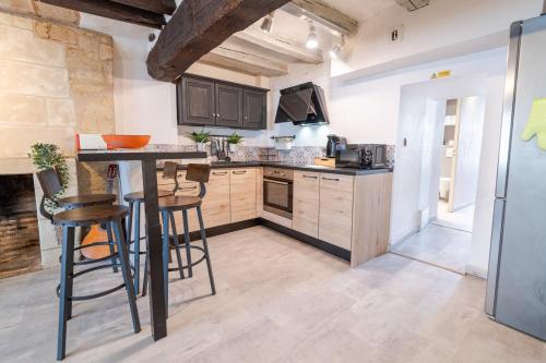 une cuisine avec des placards en bois et un bar avec des tabourets dans l'établissement Le cocon authentique, à Tours