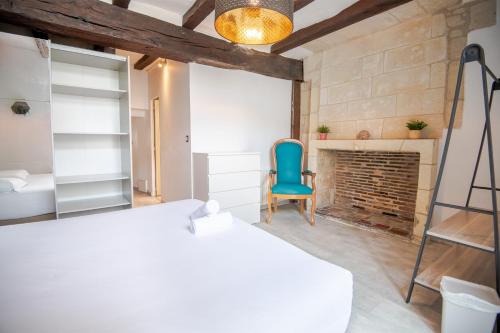 Cette chambre dispose d'une chaise bleue et d'une cheminée. dans l'établissement Le cocon authentique, à Tours