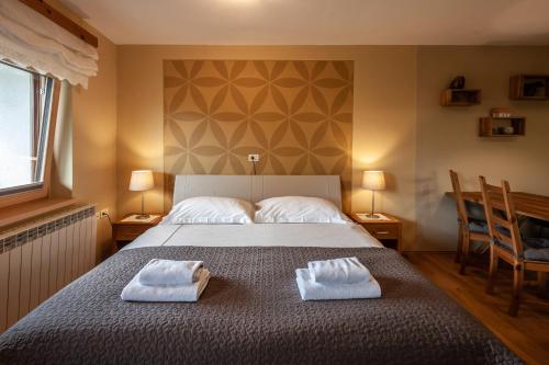 a bedroom with a bed with two towels on it at Tourist Farm Kranjc in Kobarid