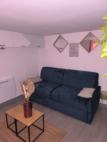 un salon avec un canapé bleu et une table dans l'établissement Studio moderne situé à 300m du cœur de Troyes, à Troyes