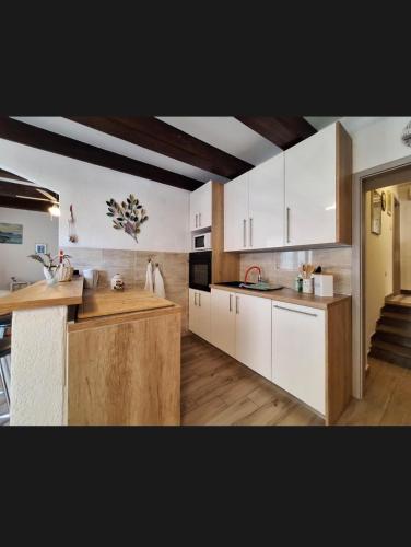 a kitchen with white cabinets and a counter top at Apartment EMMA in Povile