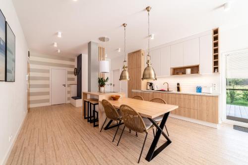a kitchen and dining room with a wooden table and chairs at Nautica Resort in Giżycko