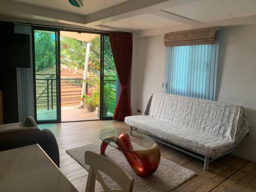 a living room with a couch and a glass table at Penthouse Crystal Bay Apartments in Ban Lamai