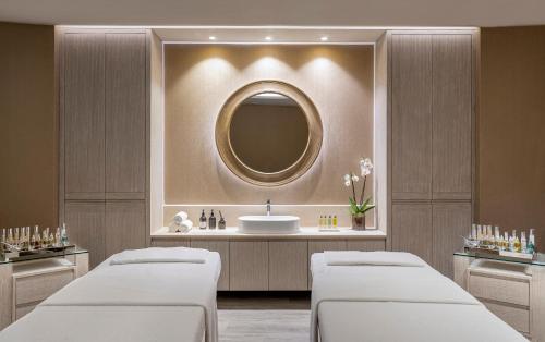 a spa room with two beds and a mirror at Porto Sani in Sani Beach