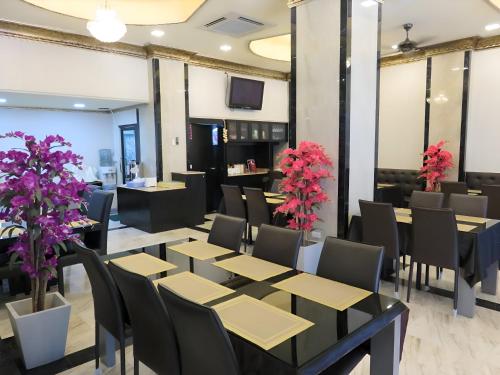 a dining room with tables and chairs and purple flowers at Land Royal Residence Pattaya in Pattaya South